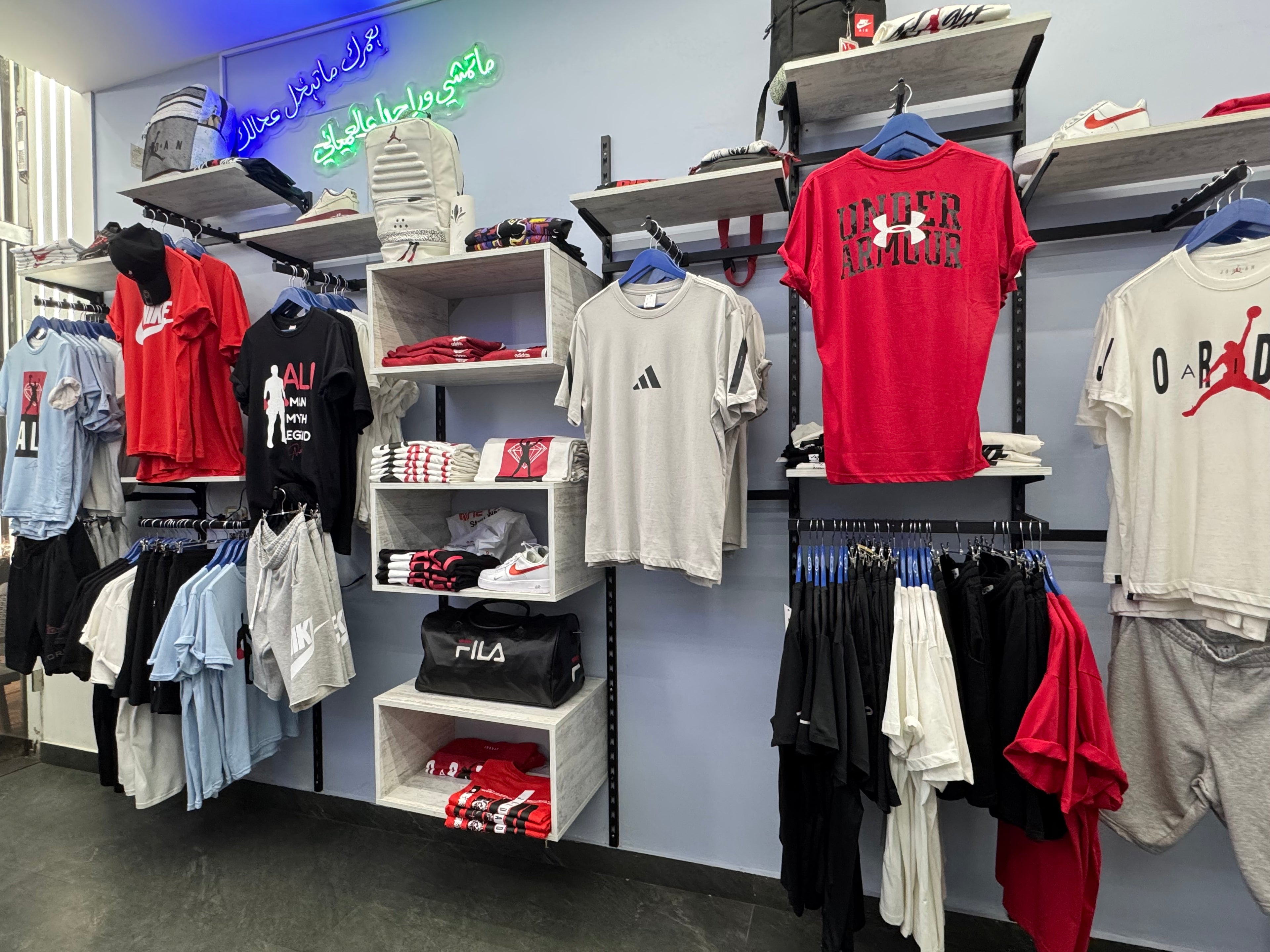 Clothing store interior with various shirts and accessories on display.